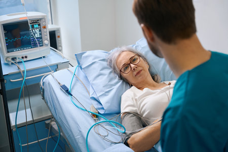 Elderly lady is connected to a patient monitorの写真素材