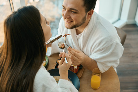 Young couple in love at romantic breakfast in cozy settingの写真素材