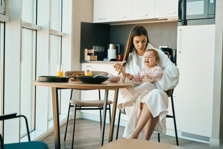 Small child cries in the arms of a young motherの写真素材