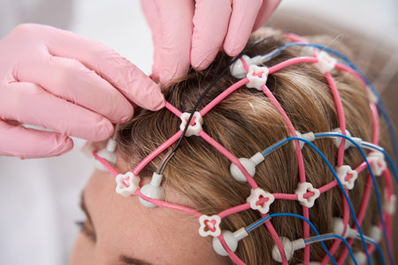 Health worker attaches a cap with electrodes to patients head