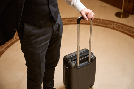 Man standing with suitcase in the hotel lobbyの写真素材