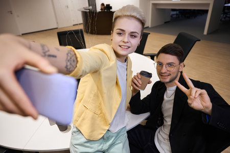 Bloggers taking selfie together in the officeの写真素材