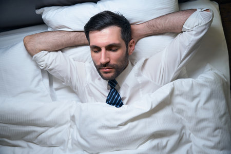 Man, without undressing, fell asleep in office clothes, in a comfortable bed