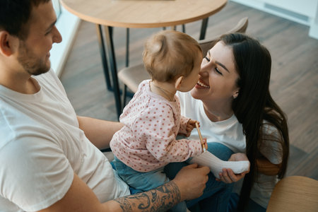 Parents happily spend time with their little daughter in kitchenの写真素材