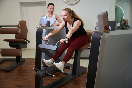 Beautiful woman is engaged in a modern fitness machine