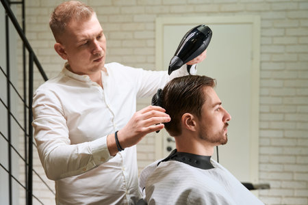 Hairdresser at work in a well-lit workplaceの写真素材