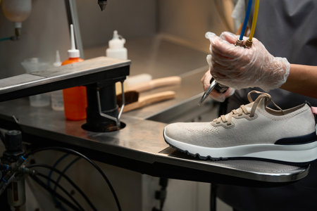 Dry-cleaning service operator cleaning sneakers with special steam gunの写真素材