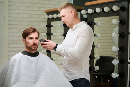 Barber workplace works with a male client, indoors modern interiorの写真素材