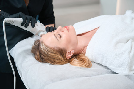 Blonde woman is having a hardware facial skin tightening procedureの写真素材