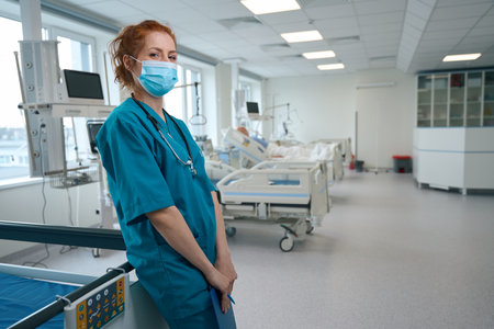 Doctor with medical face mask standing in the reanimation wardの写真素材