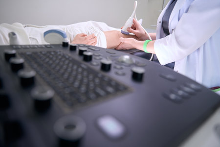 Diagnostician uses modern equipment for ultrasound of the knee joint