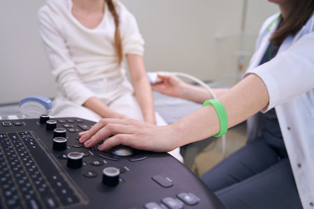 Female doctor conducts examination of a child on ultrasound machineの写真素材