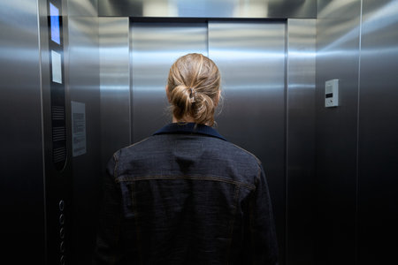 Male in a denim jacket is in passenger elevator cabinの写真素材