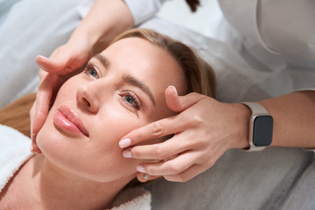 Masseuse makes a professional face massage to the patientの写真素材