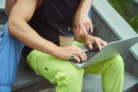 Young man sitting back to his girlfriend in park
