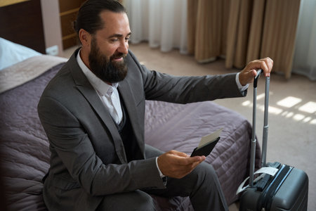 Businessman sat down on the bed to rest from roadの写真素材