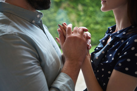 Man and a woman tenderly hold hands