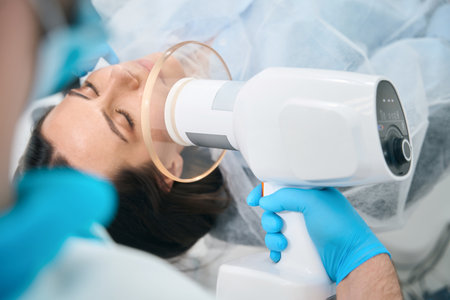 Male dentist holds in his hands special lamp for photopolymer fillingsの写真素材