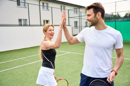 Female and male greet each other on the tennis courtの写真素材