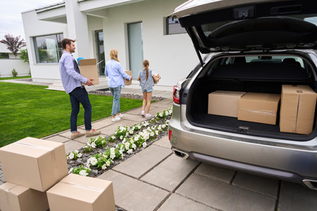 People carry cardboard boxes with things from car to new house