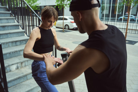 Guy helps his girlfriend to master scooter for walking around cityの写真素材