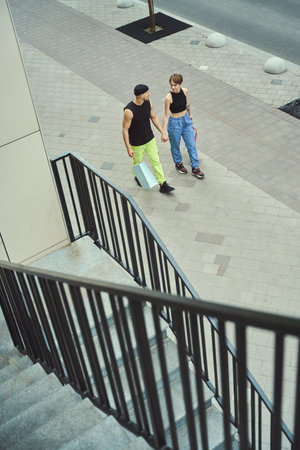 Guy and his girlfriend are walking along the sidewalkの写真素材