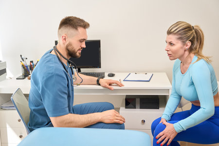 Woman visiting orthopedist to complain for pain in her kneeの写真素材