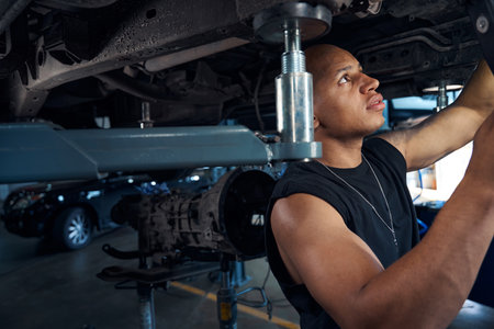 Auto-mechanic checking car-lift before lifting automobiles for maintenanceの写真素材