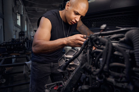 Serious auto-mechanic going through carburetor, checking serviceabilityの写真素材
