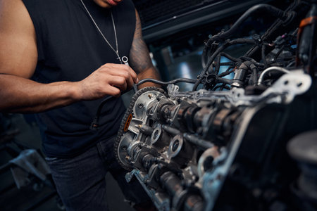 African-American auto-mechanic engaging in car engine repairingの写真素材