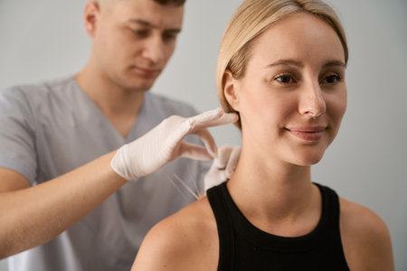 Male reflexologist conducts an acupuncture session for an expectant motherの写真素材