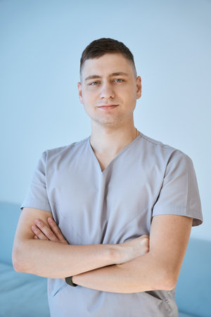 Young man stands at his workplace with his arms crossedの写真素材
