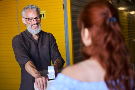 Man and a woman are packing things in cardboard boxesの写真素材