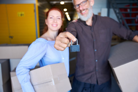 Smiling people stand with boxes of things in a warehouseの写真素材