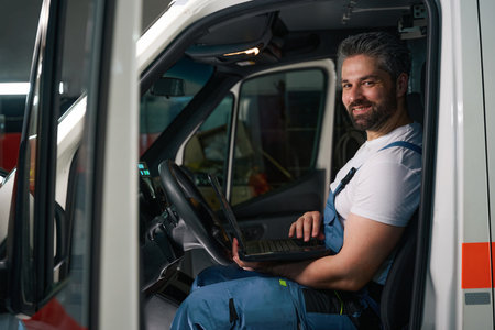 Joyous automotive mechanic conducting computer diagnostics on motor vehicle