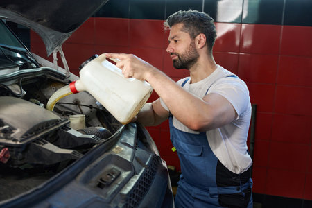 Focused auto mechanic is maintaining client automobileの写真素材