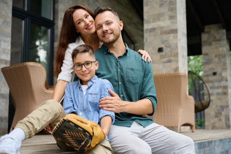 Young parents and son, hugging, settled down on the terraceの写真素材