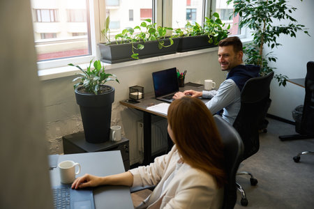 Man and a woman communicate in a comfortable, bright office