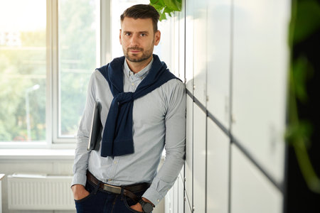 Young manager standing by storage lockersの写真素材