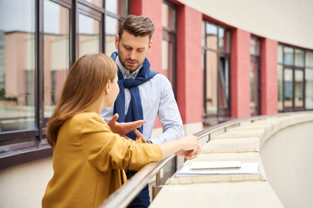 Managers communicate on a large balcony of an office buildingの写真素材