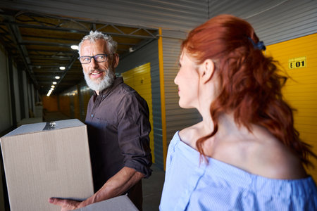 Bearded middle-aged man is in storage warehouse with his companion