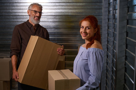 People loading cardboard boxes with things into a storage containerの写真素材
