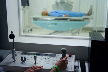 Radiologic technologist performing diagnostic radiography on adult womanの写真素材