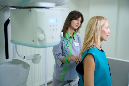 Radiologic technologist shielding patient body from harmful radiation exposureの写真素材