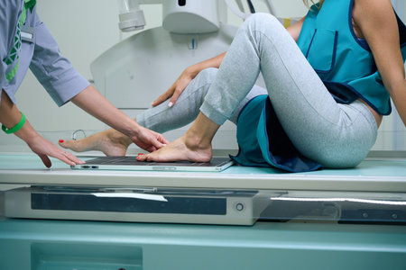 Experienced radiographer preparing patient for radiography of toesの写真素材