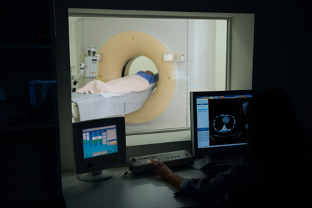 Radiographer performing diagnostic computed tomography on female patientの写真素材