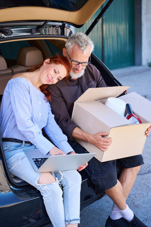 People sat on the edge of the open trunkの写真素材
