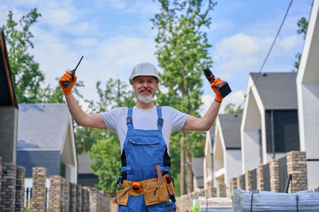 Cheerful builder posing for camera on building siteの写真素材