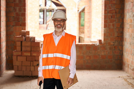 Joyous foreman posing for camera during building site inspection