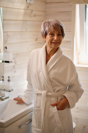 Smiling elderly lady is in the bathroomの写真素材